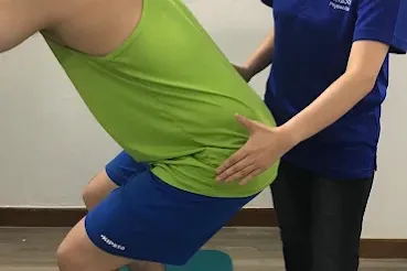 Physiotherapist supporting a patient during a balance exercise.